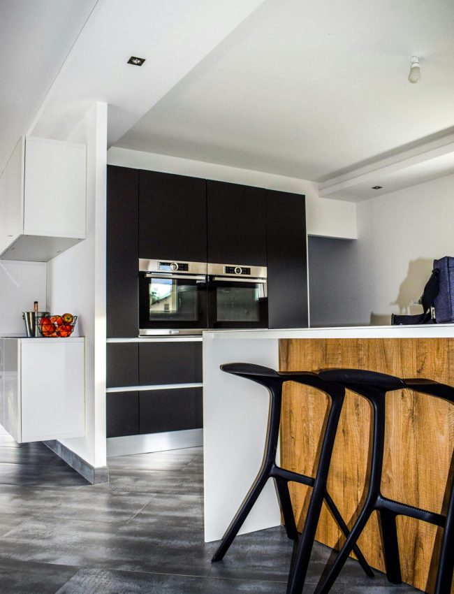A contemporary kitchen featuring sleek cabinetry and elegant bar stools in a minimalist design.